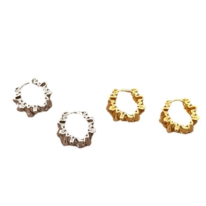 Boucles d'oreilles créoles vintage à vagues irrégulières en or et argent sur fond blanc
