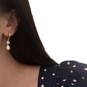 Baroque pearl drop earrings with gold hoops on female model for vintage french look