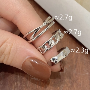 Macro shot of silver stackable rings set featuring curb chain and star engraved wave designs