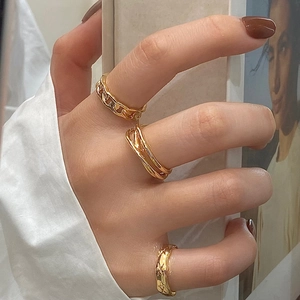 Three-piece gold geometric ring set with chain and star motifs on female model hand