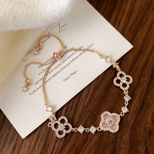 Detail of rose gold clover bracelet with pink shell inlay and adjustable slider clasp