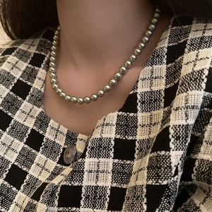 Elegante collana di perle tonde grigio argento con lucentezza metallica sulla modella