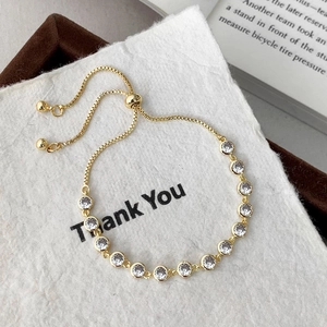 Detail of adjustable gold bracelet with 14 white cubic zirconia stones in macro view