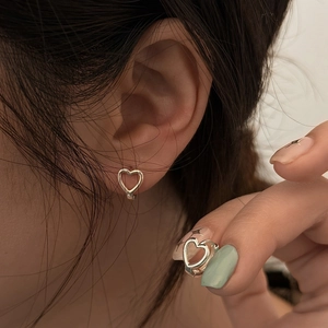 Dettagli di orecchini minimalisti in argento a forma di cuore cavo per donna