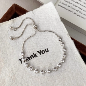 Macro detail of silver adjustable bracelet with round clear cubic zirconia stones