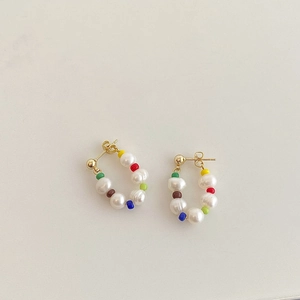 Colorful seed beads and freshwater pearl hoop earrings with gold finish on beige background