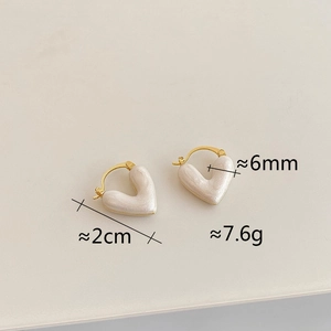 Detail view of heart earrings showing 2cm width and 6mm thickness on white background
