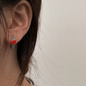 Detail shot of heart-shaped red glaze pendant earring with turquoise texture hoop