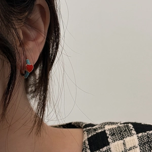 Elegant red and blue heart-shaped drop glaze hoop earrings with gold-plated finish on a model