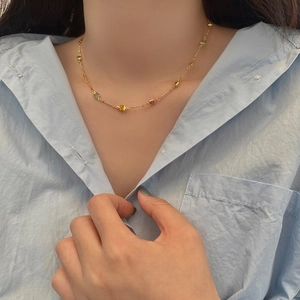 Détail d'un collier doré avec des pierres précieuses multicolores de coupe carrée