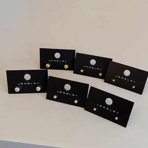 Minimalist gold and silver ball stud earrings set in six various sizes on a jewelry card