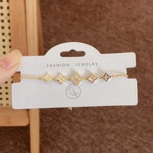 Adjustable gold four-leaf clover bracelet with white inlay and micro-pave crystals