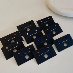 Detailed set of colorful minimalist bean stud earrings arranged on black display cards