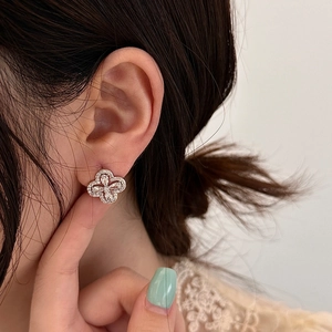 Boucles d'oreilles fleurs étincelantes en zircon cubique avec finition dorée portées
