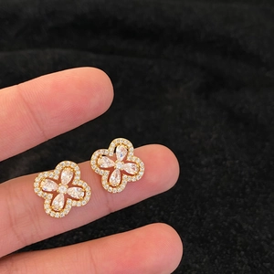 Gros plan sur des boucles d'oreilles fleurs dorées avec zircons sur velours noir