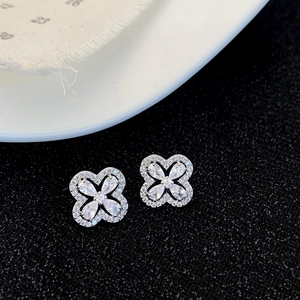 Vue détaillée de boucles d'oreilles fleurs en zircone étincelant sur fond noir chic