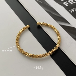Detail of a 4mm gold textured open bangle with spherical ends and 14.5g weight