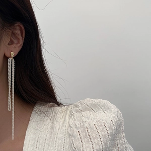 Elegant long fringe tassel drop earrings with gold irregular round studs on a model