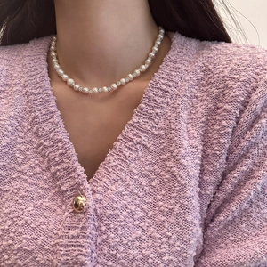 Detailed view of freshwater pearl necklace with sparkling diamond beads on a model