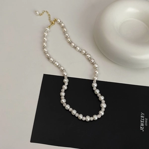 Detailed macro view of freshwater pearl necklace with sparkling pavé beads and gold clasp