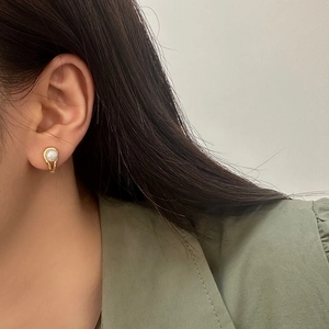 Elegant French style pearl earrings with gold U-shaped base on a female model