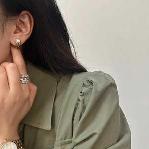 On-ear display of minimalist pearl stud earring and crystal leaf open ring in silver
