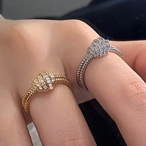 Double-layer knot ring set in gold and silver finish featuring zircon pave accents