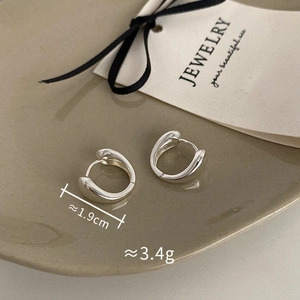 Macro shot of silver minimalist oval hoop earrings showing dimensions 1.9cm and 3.4g weight