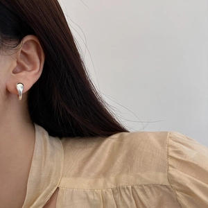 Sleek silver teardrop earrings with a polished mirror finish on model