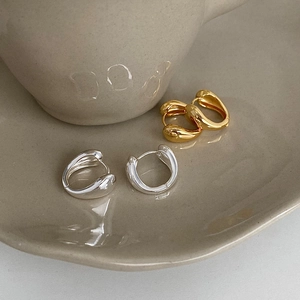 French style teardrop hoop earrings in gold and silver finish on a ceramic tray