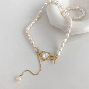 Détail du collier de perles baroques avec cœur en nacre et fermoir à bascule doré
