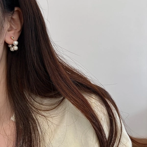 Detail of cluster freshwater pearl earrings in floral shape worn by a female model