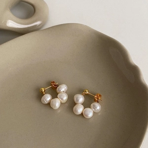 Detailed shot of five natural freshwater pearls arranged in a circular gold drop earring