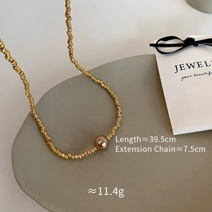 Detail view of gold bead necklace with champagne pearl and size measurement specs