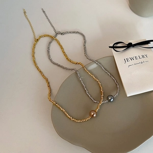 Irregular beaded necklace with gold and silver rope chains featuring elegant single pearls