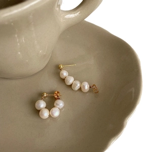 Elegant gold freshwater pearl earrings set with curved and circular vintage designs