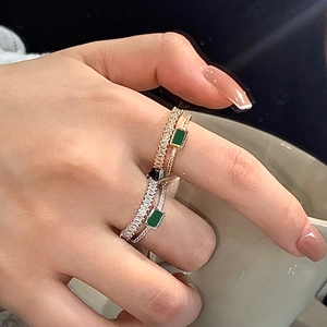 Elegant gold and silver ring set with emerald green zircon shown in lifestyle display