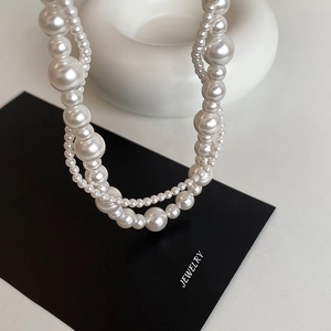Collier de perles français double couche avec perles de tailles variées sur fond blanc