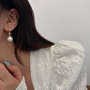 Boucles d'oreilles vintage en perles et zircon portées par un mannequin en dentelle