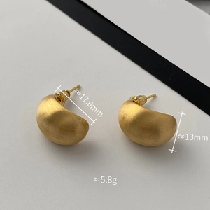 Dettaglio macro di orecchini a perno dorati opachi con dimensioni di 17,6 mm e 13 mm