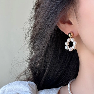 Détail de boucles d'oreilles en perles d'eau douce en forme de couronne sur mannequin