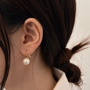 Nahaufnahme eleganter 10mm Perlenohrringe mit vergoldetem Verschluss am Modell getragen