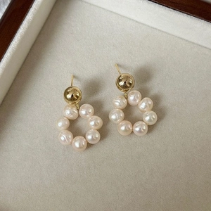 Boucles d'oreilles créoles dorées avec perles d'eau douce dans un écrin à bijoux de luxe