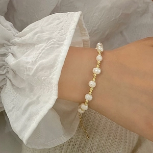 Gros plan détaillé d'un bracelet en perles d'eau douce avec perles dorées au poignet