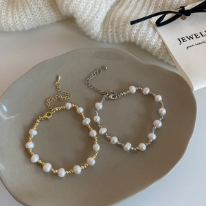 Vue à plat de bracelets en perles d'eau douce avec perles en métal doré et argenté sur plateau