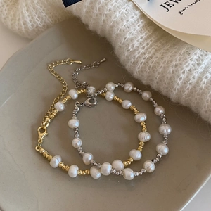 Bracelets en perles d'eau douce avec perles dorées et argentées sur fond gris texturé