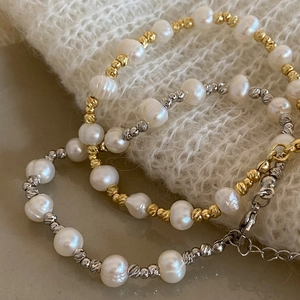 Gros plan de bracelets en perles d'eau douce avec perles en métal texturé or et argent