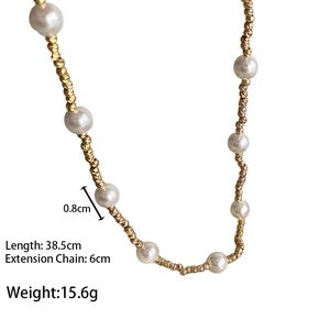 Détail du collier de perles dorées montrant les billes de 0,8 cm et la longueur