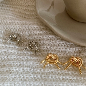 Elegant knotted bow stud earrings in silver and gold finishes with rope texture