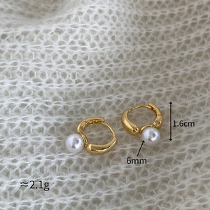 Détail de boucles d'oreilles en or de 1,6cm avec perles blanches de 6mm sur tricot